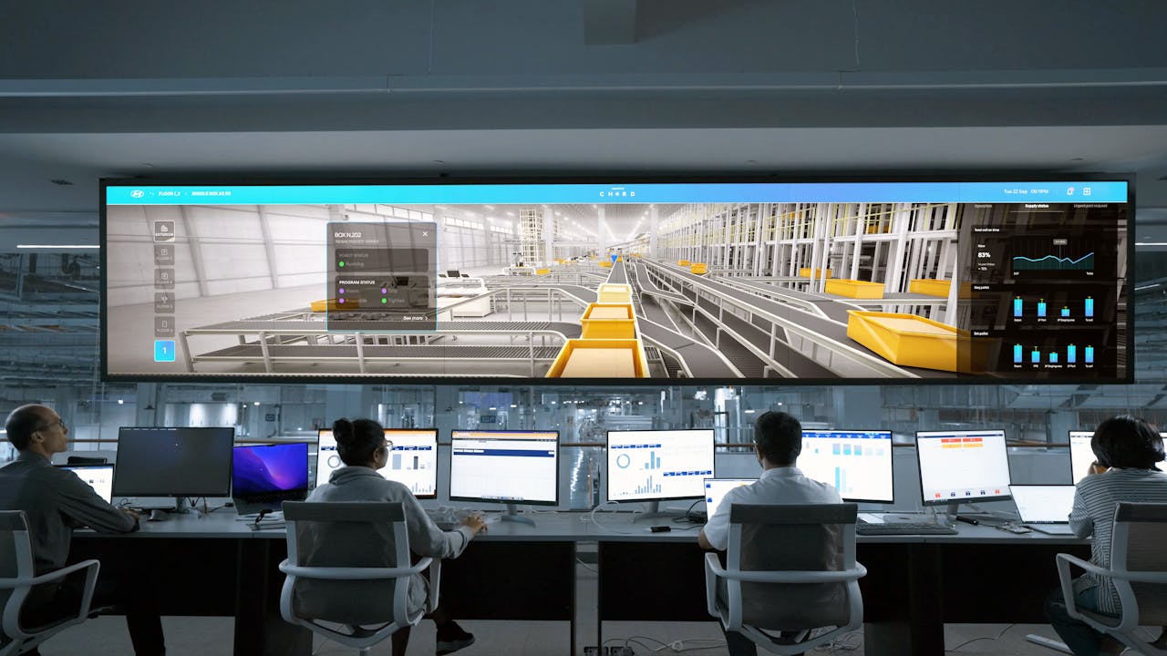 creative Modern control room with people monitoring large digital displays and computer systems.