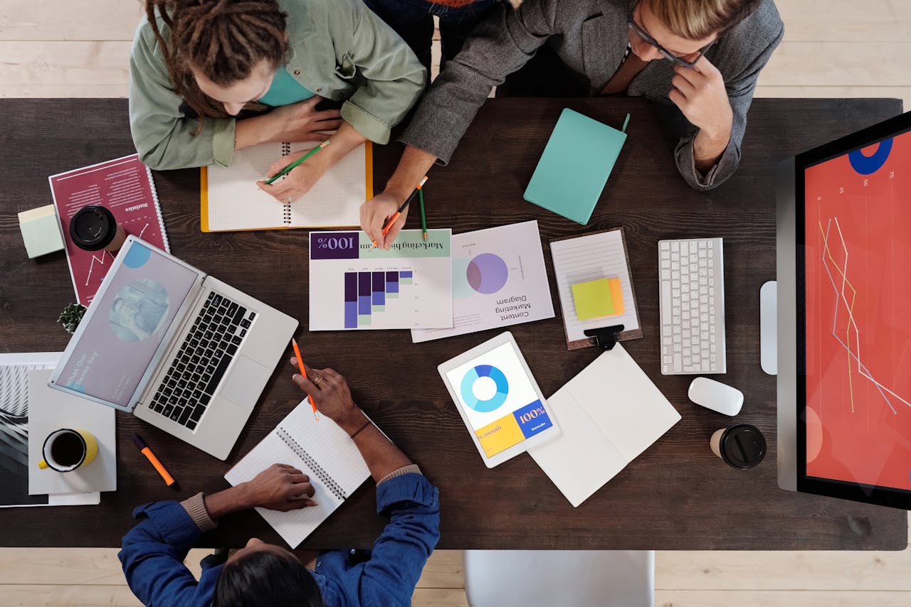 digital Overhead view of a diverse team collaborating on a project in a modern office setting.